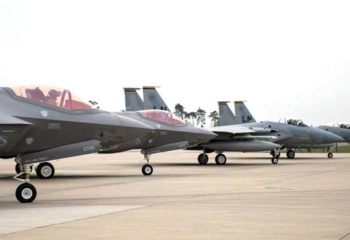 Photograph of American F-15 Eagle and F-35 Lighting II fighters on the tarmac.